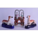 A PAIR OF 19TH CENTURY STAFFORDSHIRE GREYHOUNDS together with a Staffordshire figural group. Dogs 16