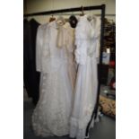 FOUR EARLY WEDDING DRESSES together with a Victorian parasol. (5)