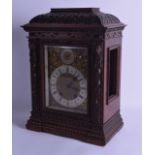 A LATE VICTORIAN CARVED WALNUT BRACKET CLOCK carved with extensive lion mask heads and vines, with