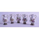 A SET OF FIVE LATE 19TH CENTURY GERMAN TWIN HANDLED PORCELAIN VASES with silver mounts, painted with