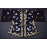 AN EARLY 20TH CENTURY CHINESE DARK BLUE SILKWORK ROBE decorated with butterflies, and scattered