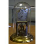 A BRASS GLASS DOMED ANNIVERSARY CLOCK.