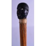 A GOOD 19TH CENTURY CARVED WHALE BONE WALKING CANE with Ethnic carved portrait terminal. 83 cm