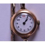 A 9CT YELLOW GOLD LADIES WRISTWATCH with white enamel dial. 2.25 cm wide.