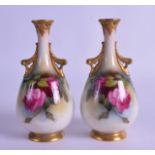 A PAIR OF ROYAL WORCESTER TWIN HANDLED PORCELAIN VASES painted with roses and trailing vines.