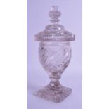 A GOOD REGENCY CUT GLASS VASE AND COVER with swirling decoration, supported upon a square foot. 32