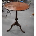 A GEORGE III STYLE PIE CRUST OCCASIONAL TABLE upon three splayed legs.