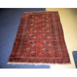 AN EASTERN RED GROUND CARPET decorated with motifs. 190 cm x 120 cm.