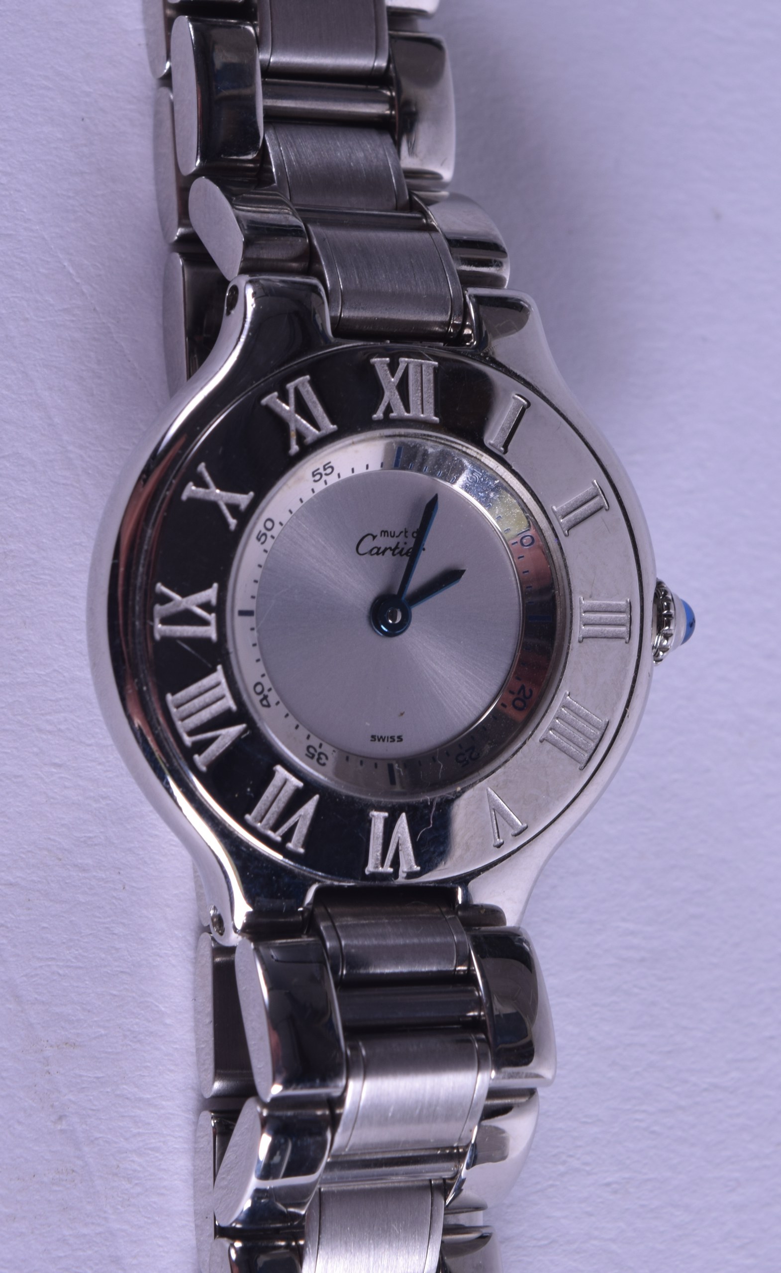 A LADIES STAINLESS STEEL CARTIER WRISTWATCH with sapphire cabochon winder. 2.5 cm wide.