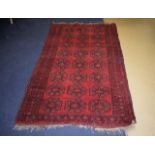 A PERSIAN RED GROUND CARPET decorated with black motifs. 202 cm x 114 cm.