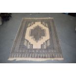 A PERSIAN BEIGE GROUND RUG decorated with a large central motif. 171 cm x 121 cm.