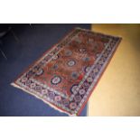 AN EASTERN CORAL GROUND RUG decorated with floral motifs. 210 cm x 114 cm.