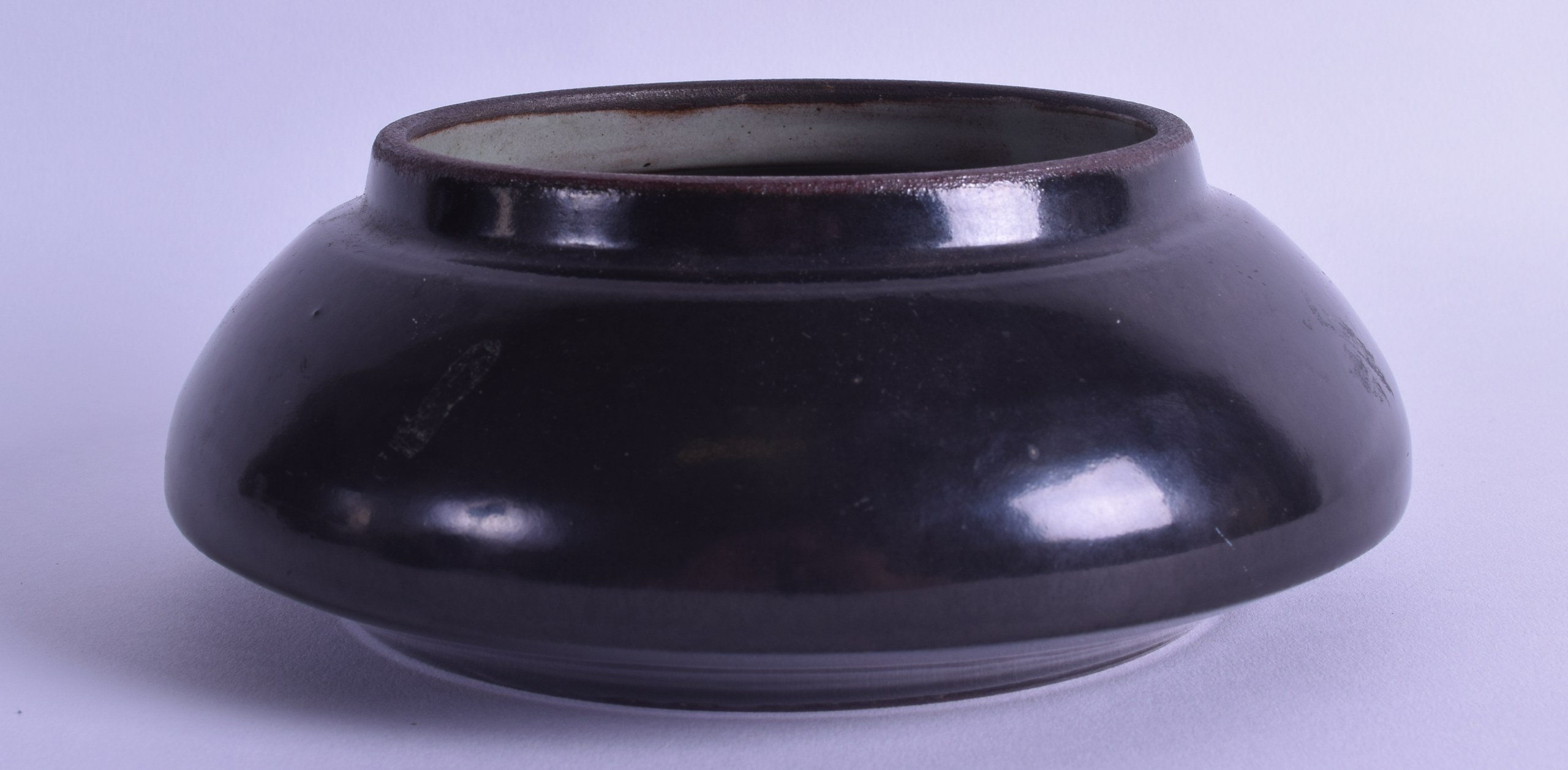 A BROWN GLAZED STONEWARE CIRCULAR BOWL of squat form. 16 cm diameter.