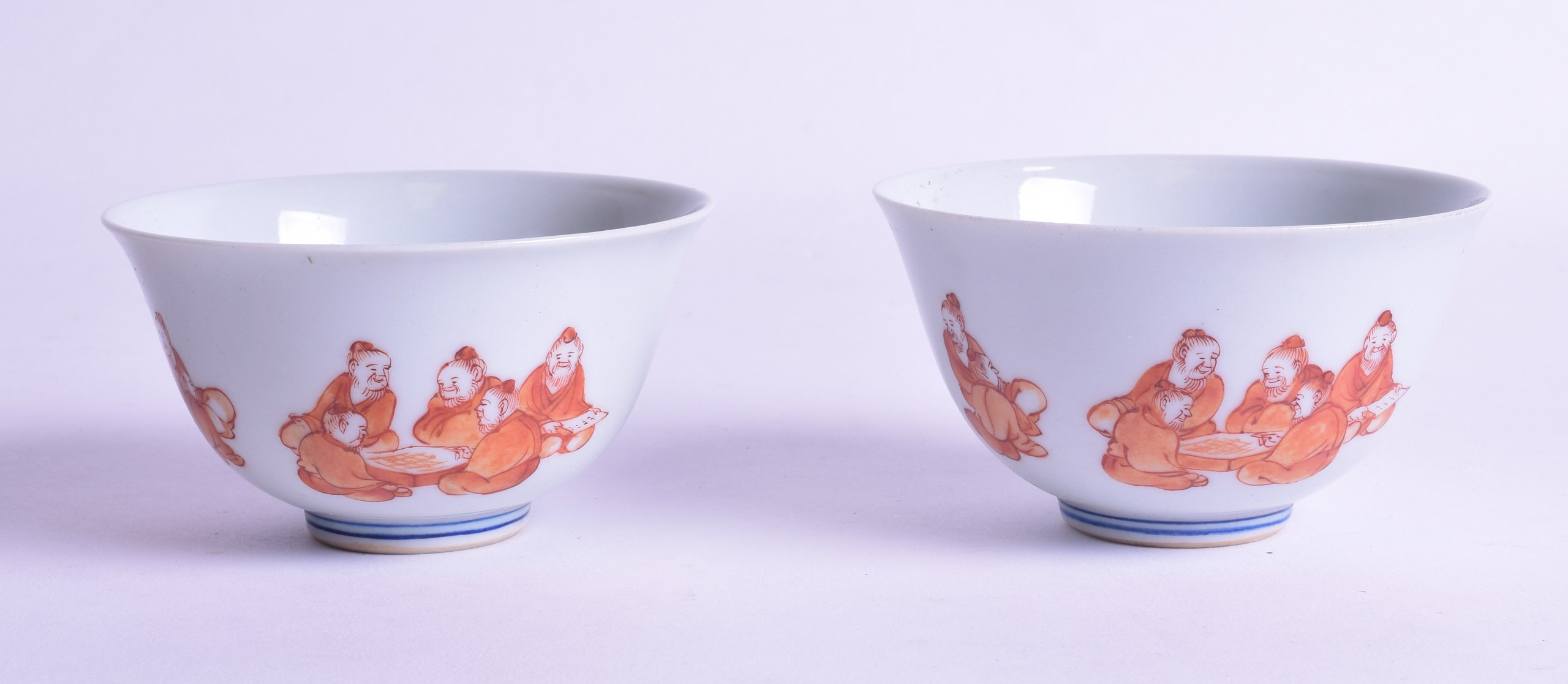 AN UNUSUAL PAIR OF EARLY 20TH CENTURY CHINESE IRON RED BOWLS painted with figures seated within