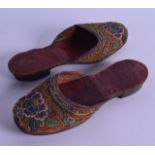 A PAIR OF 19TH CENTURY JEWELLED LEATHER BACKED SHOES with floral decoration. 21 cm long.