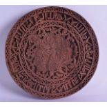 AN UNUSUAL ISLAMIC CIRCULAR CARVED WOODEN PANEL decorated with extensive calligraphy and a bird of