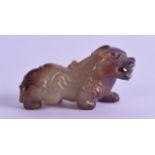 A CHINESE CARVED MUTTON JADE FIGURE OF A STYLISED BEAST with russet inclusions, modelled in a