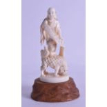 A 19TH CENTURY JAPANESE MEIJI PERIOD CARVED IVORY OKIMONO modelled as a male standing upon a