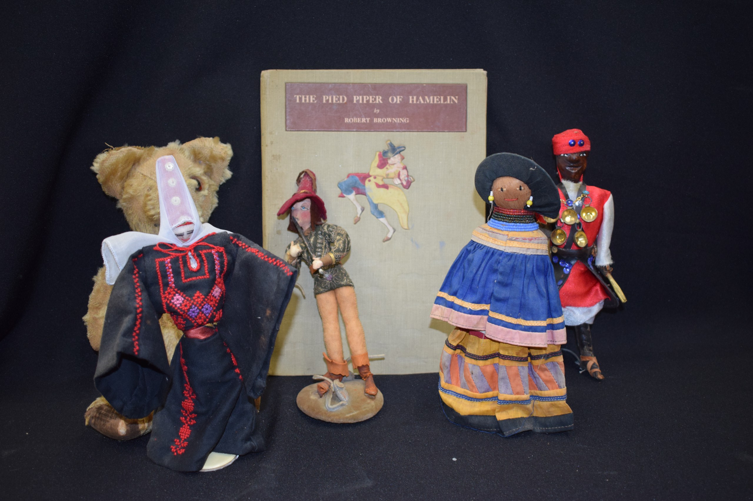 A VINTAGE PIED PIPER DOLL AND BOOK, together with three other dolls and a teddy bear. (6)