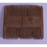 A VERY EARLY MIDDLE EASTERN CARVED WOOD COMB the central banding incised with calligraphy. 8.25 cm x