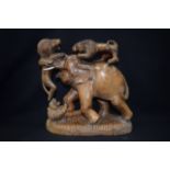 A CARVED HARDWOOD GROUP, formed as two lions attacking an elephant. 33 cm x 30 cm.