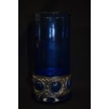 AN ARTS & CRAFTS STYLE BLUE GLASS VASE, with embossed white metal banding. 24 cm high.