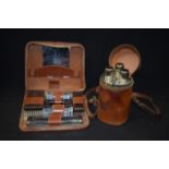 A VINTAGE LEATHER CASED TRAVELLING TANTALUS, together with a part complete gentlemens cased grooming