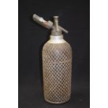 A VINTAGE SODA SYPHON, body covered with metal mesh. 34 cm high.