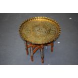 AN EASTERN BRASS TOP OCCASIONAL TABLE, engraved with symbols. 45 cm wide.