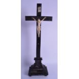 AN EARLY 19TH CENTURY CONTINENTAL CARVED IVORY CRUCIFIX modelled upon a stepped ebonised base. 51 cm