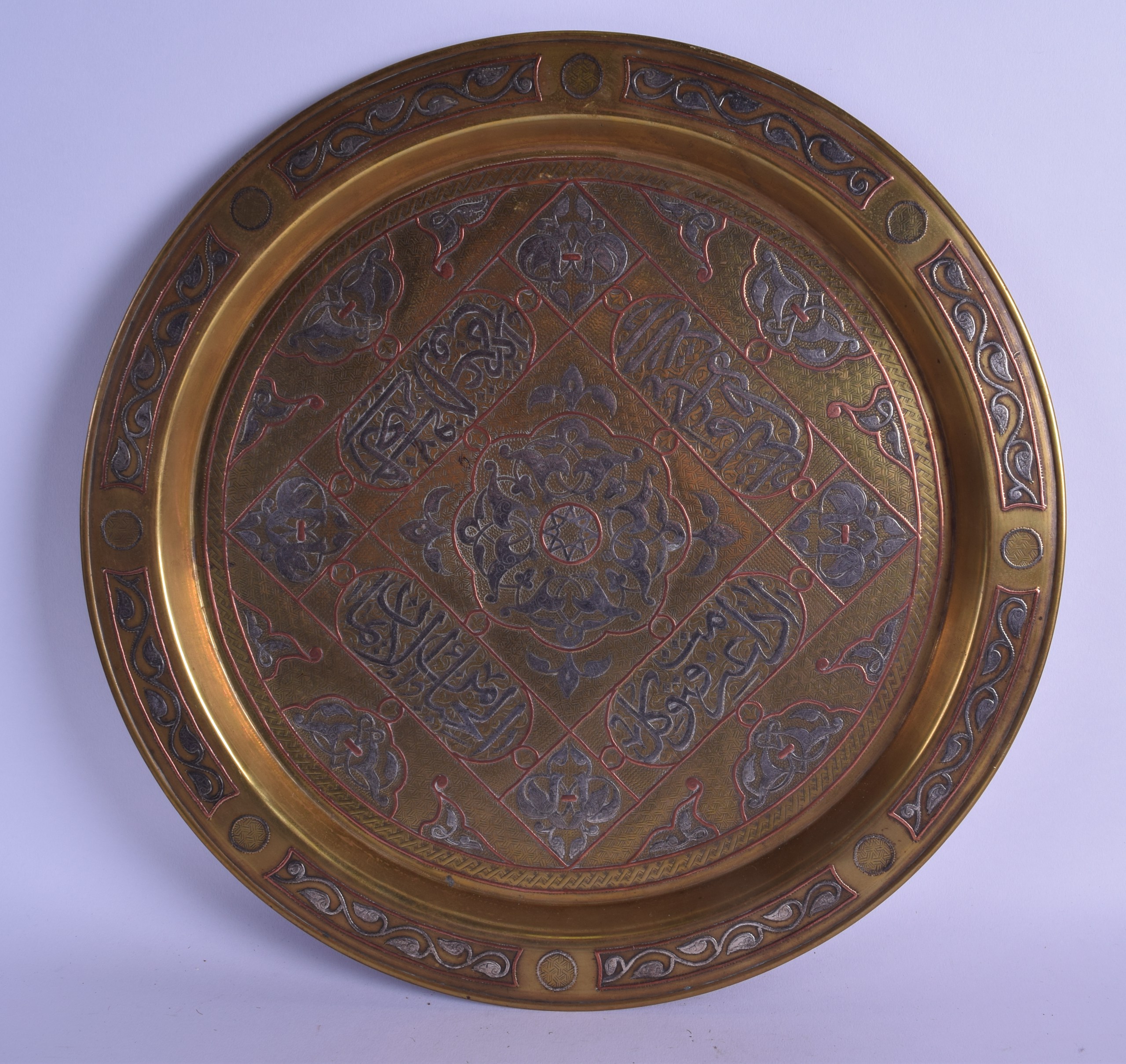 A 19TH CENTURY PERSIAN SILVER INLAID MIXED METAL AND BRASS CIRCULAR DISH decorated with scrolling