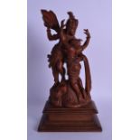 A 19TH CENTURY INDIAN CARVED WOOD FIGURE OF A MALE AND FEMALE modelled upon a rocky outcrop. 34 cm