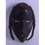 AN AFRICAN CARVED TRIBAL DAN WOOD MASK in the form of a female. 16 cm x 23 cm.