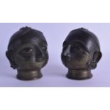 A PAIR OF EARLY 20TH CENTURY AFRICAN BENIN BRONZE HEADS modelled with humerous expressions. 10 cm