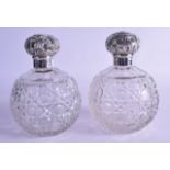 A PAIR OF EDWARDIAN SILVER TOPPED CUT GLASS SCENT BOTTLES AND STOPPERS.by Asprey of London