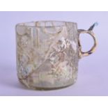 A Persian glass mug, 10th/12th Century. 10 cm wide.