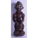 A LARGE EARLY 20TH CENTURY AFRICAN POLYCHROMED WOODEN FIGURE OF A MALE modelled playing a drum. 47.5