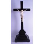 A VERY LARGE 19TH CENTURY EUROPEAN CARVED IVORY CRUCIFIX modelled upon a large ebonised cross.