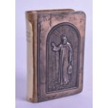 AN UNUSUAL ENGLISH SILVER MOUNTED PRAYER BOOK depicting a roaming saint. 6 cm x 9 cm.