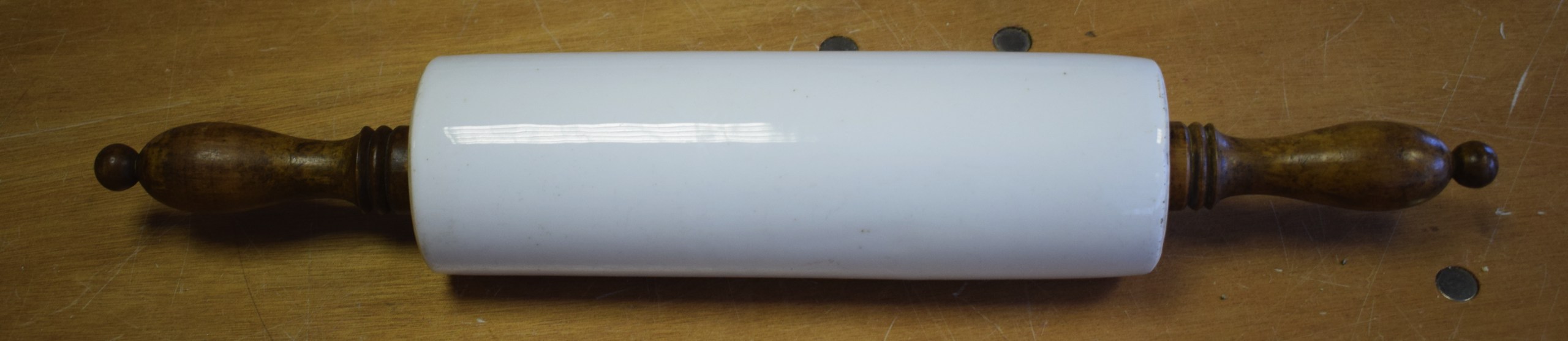 A VINTAGE POTTERY TWIN HANDLED ROLLING PIN.