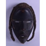 AN AFRICAN CARVED TRIBAL DAN WOOD MASK in the form of a female. 16 cm x 23 cm. Wear, flaw to under