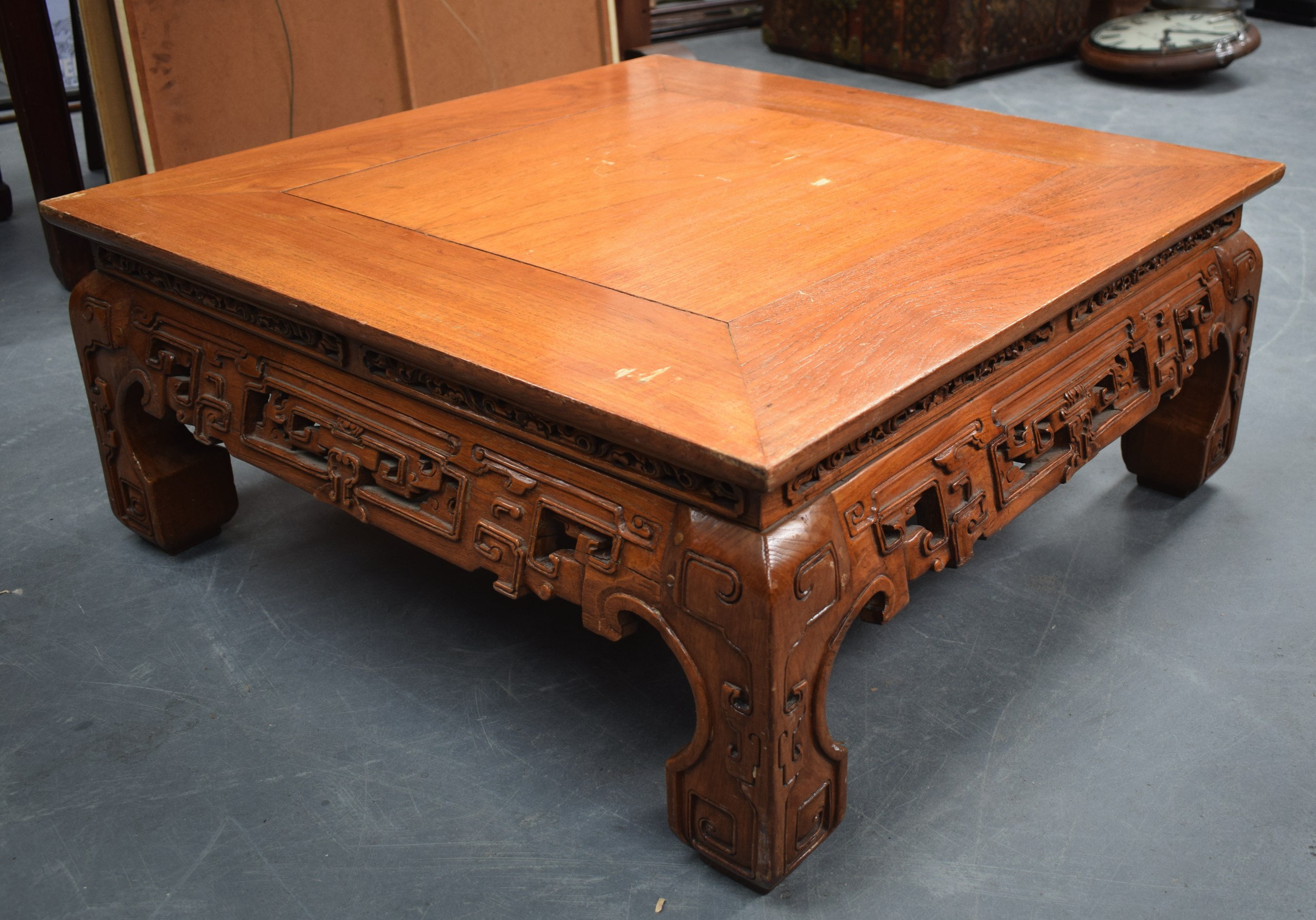 AN EARLY 20TH CENTURY CHINESE CARVED SOFTWOOD LOW TABLE with carved frieze. 80 cm square x 32 cm.