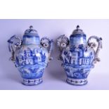 A LARGE PAIR OF 19TH CENTURY CONTINENTAL FAIENCE DELFT VASES AND COVERS painted with buildings and