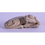 A CHINESE CARVED JADE FIGURE OF A RECUMBANT BEAST modelled recumbent, its head looking in reverse.