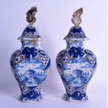 A PAIR OF 18TH CENTURY CONTINENTAL FAIENCE DELFT VASES AND COVERS painted with a fountain and