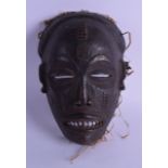 AN AFRICAN TRIBAL CARVED WOOD MASK modelled as a scowling male. 15 cm x 19 cm. Minor chips to rim