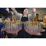 A LARGE PAIR OF BRASS CHANDELIERS, with pink glass droplets. 43 cm wide.