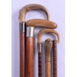 A GROUP OF FOUR LATE VICTORIAN/EDWARDIAN HORN HANDLED CANES together with a spare bamboo shaft.