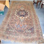 AN ANTIQUE ORNAGE GROUND PERSIAN RUG, decorated with flowers and symbols. 270 cm x 130 cm.