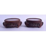 A PAIR OF EARLY 20TH CENTURY CHINESE CARVED HARDWOOD STANDS decorated with openwork foliage. 13.25